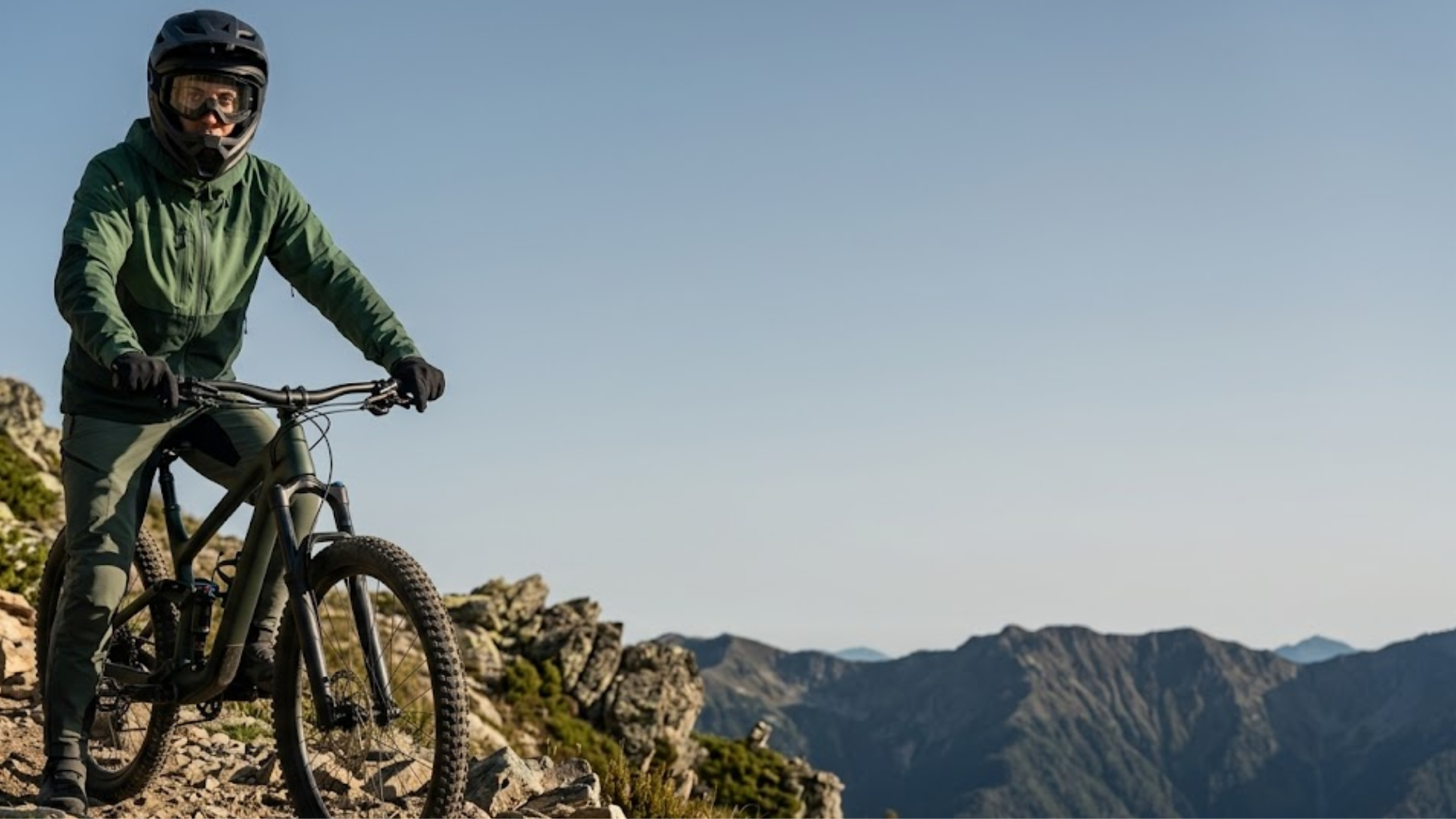 Mountain biker riding a rocky mountain trail during an outdoor adventure with scenic alpine landscape views