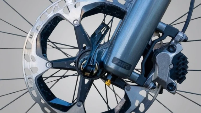 Close-up of a mountain bike hydraulic disc brake rotor and caliper mounted on a suspension fork