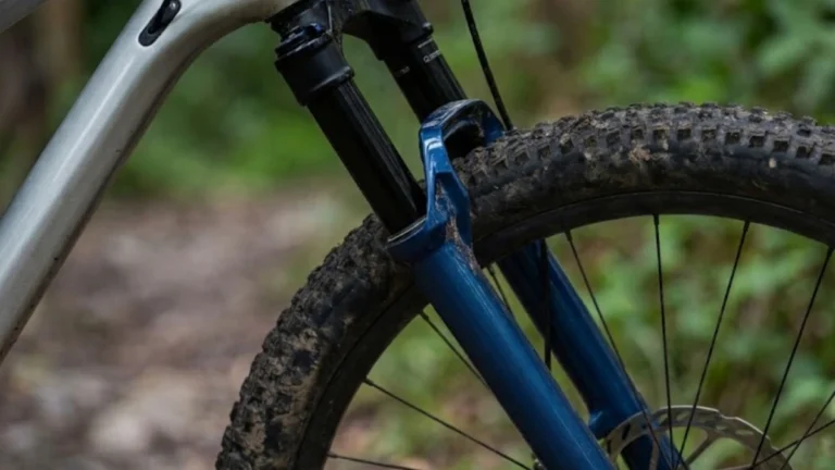 Rider adjusting the rebound dial on a mountain bike suspension fork trailside
