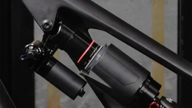 Mountain biker adjusting the rebound dial on a rear shock trailside
