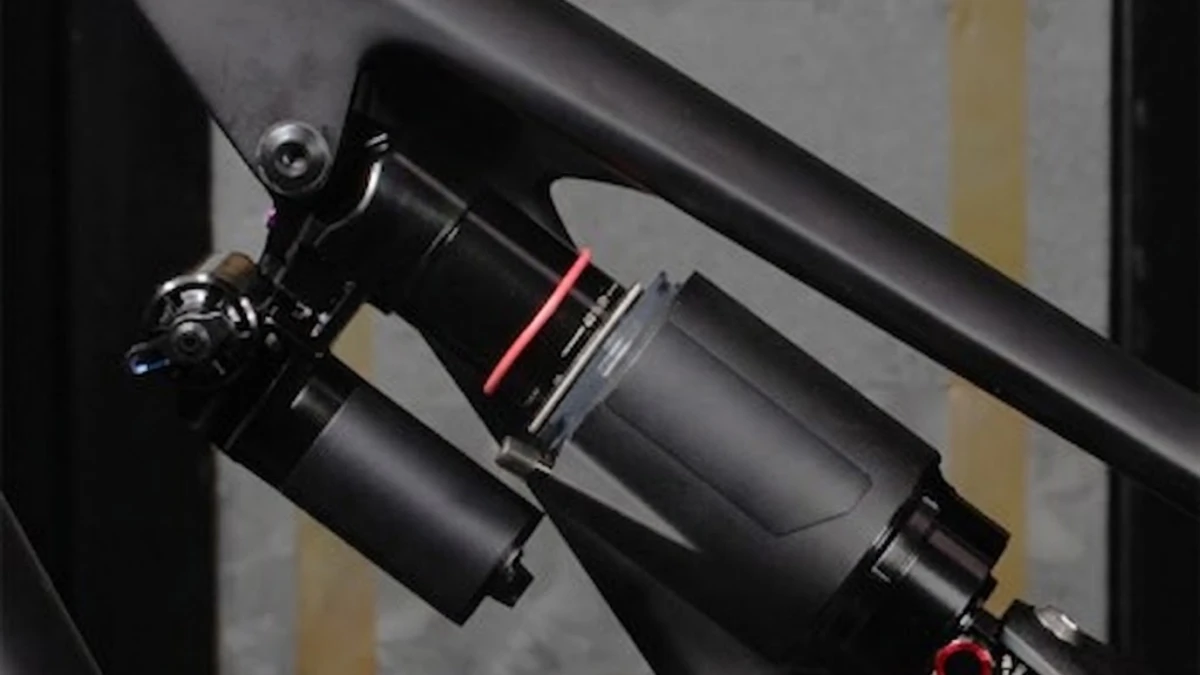 Mountain biker adjusting the rebound dial on a rear shock trailside